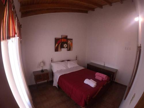 a bedroom with a bed with a red bedspread at Departamento encantador en Maipú in Maipú