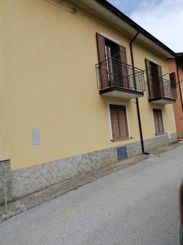 a yellow building with two balconies on a street at La casa di Pina in Latronico