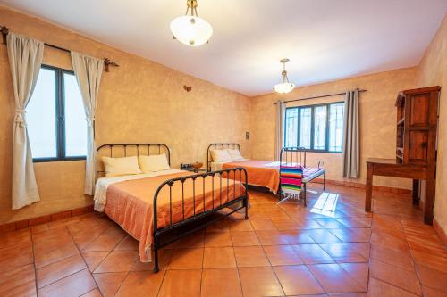 a bedroom with two beds and a table at OYO Whost San Miguel De Allende in San Miguel de Allende