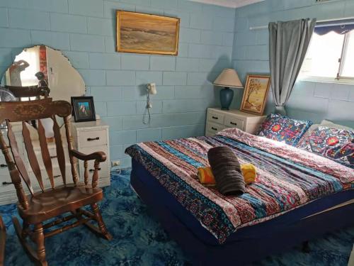 1 dormitorio con 1 cama y 1 silla en On the beach-Lucky Bay, en Cowell
