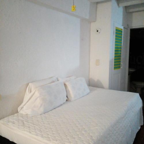 a white bed with two white pillows on it at @casa__grace in Cartagena de Indias