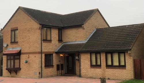 a brick house with a black roof at ASHMINA GUEST HOUSE with Free Onsite Parking in Milton Keynes