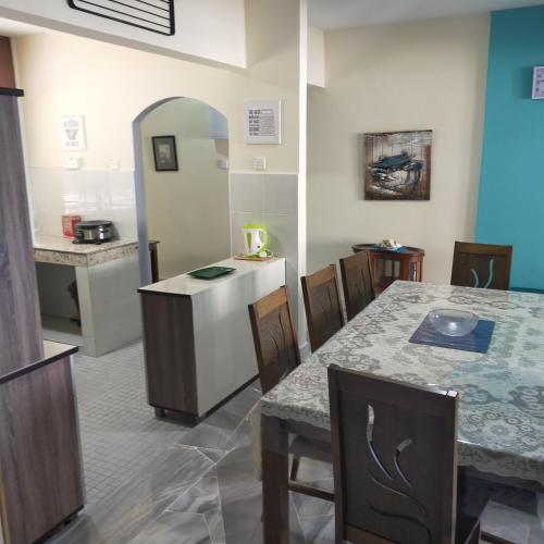 a kitchen and dining room with a table and chairs at Relaxing Retreats at Cocobay Apartments in Port Dickson