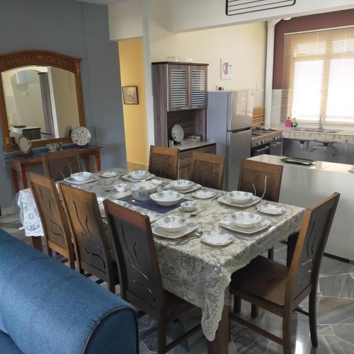 a dining room table with chairs and a kitchen at Relaxing Retreats at Cocobay Apartments in Port Dickson
