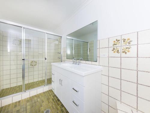 a white bathroom with a sink and a shower at Centrepoint 10 in Forster
