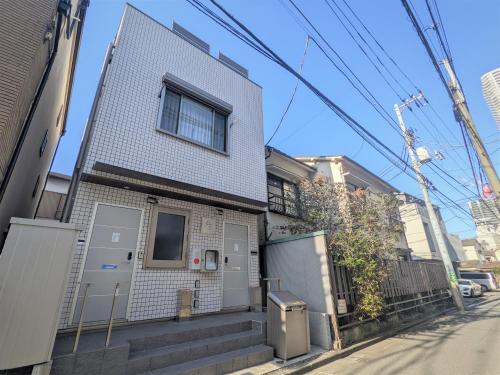 a house on a street next to a building at Lien 西新宿 in Tokyo