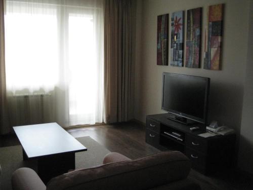 sala de estar con TV y silla en Spacious and Cosy Apartment in Bansko Royal Towers Complex, en Bansko