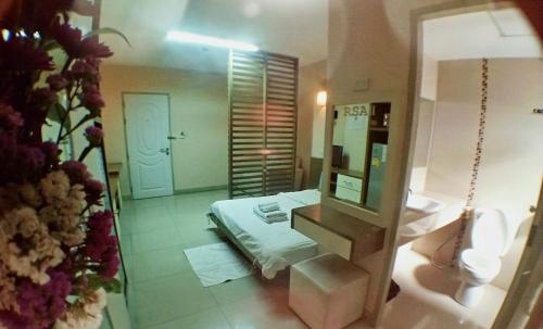a bathroom with a bed and a mirror and a sink at ruamsab2 รวมทรัพย์2 in Ban Na Song
