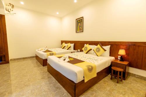 a hotel room with two beds and a lamp at Thọ Hướng Hotel - Phan Thiết in Phan Thiet
