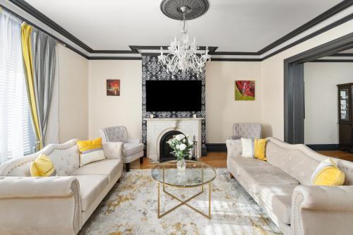 a living room with white couches and a fireplace at Centennial 6-Bedroom Waterfront Palace Sleeps 14 in Montréal