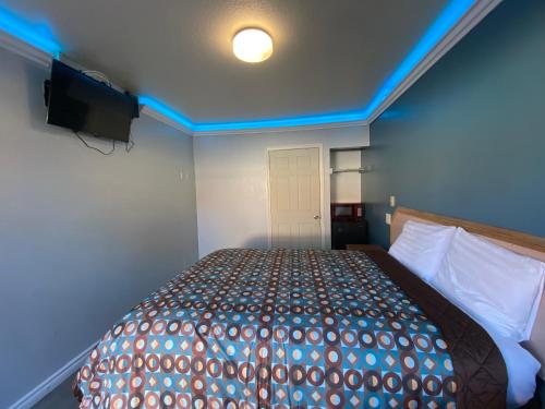 a bedroom with a bed with a light on the ceiling at Sands Inn in South Gate