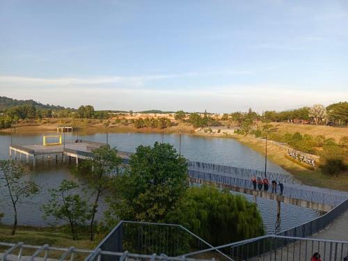 vistas a un lago con muelle y cancha de baloncesto en HOMESTAY D'TEPIAN CASA, BANDAR SERI IMPIAN KLUANG en Kluang