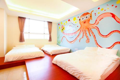 una camera con 2 letti e un murale di polpo di Mermaid B&B a Green Island