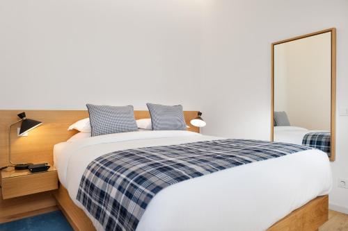 a bedroom with a large bed and a mirror at Mouzinho da Silveira Unique Apartments, by Oporto Collection in Porto