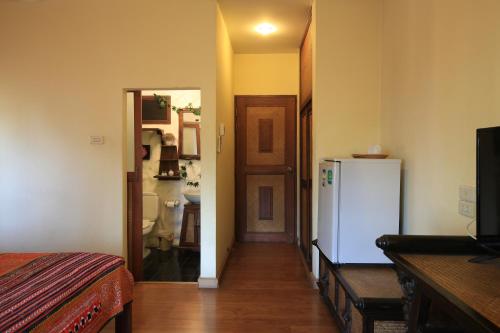 a room with a hallway with a refrigerator and a kitchen at Plumeriahome near Chiangmai Airport in Chiang Mai