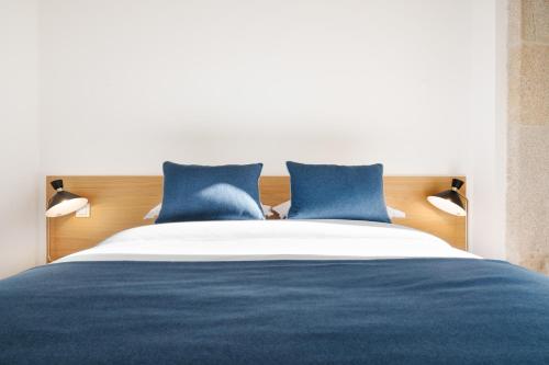 a bedroom with a blue and white bed with blue pillows at Mouzinho da Silveira Unique Apartments, by Oporto Collection in Porto