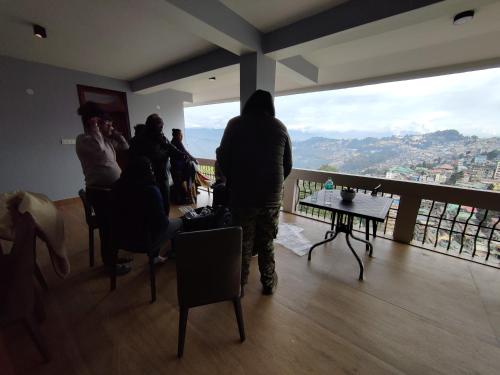 a group of people standing in a room with a view at The Silver Spring Homestay in Darjeeling