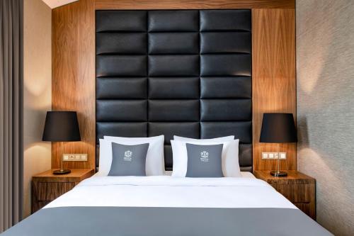 a bedroom with a large bed with two lamps at Bristol Hotel and Spa Bakuriani in Bakuriani