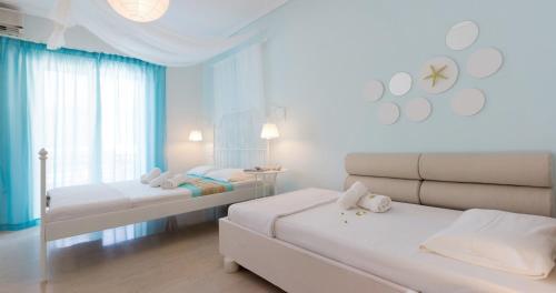 a white room with two beds and a couch at Thetis in Alikanas