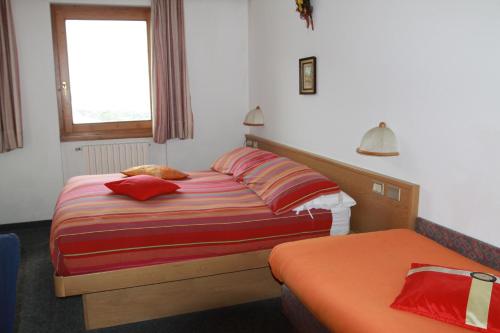 
a bedroom with a bed and a dresser at Hotel Genziana in Passo Stelvio
