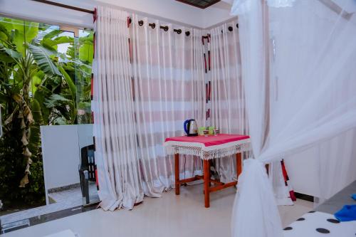 a white room with a table and a window at Sajana Ocean Hill in Mirissa