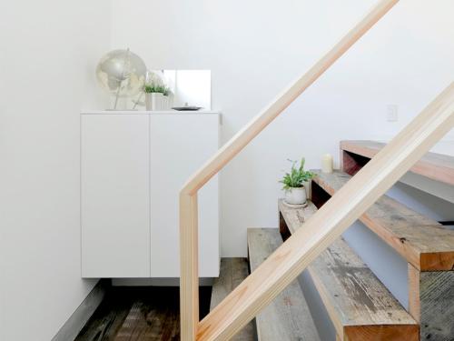 a staircase in a house with white walls and wooden floors at Oku-Shibu Residence in Tokyo