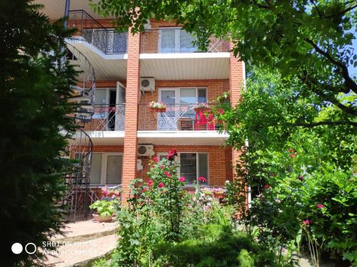 un edificio de ladrillo con flores delante en Villa Blues Guest House, en Koktebel