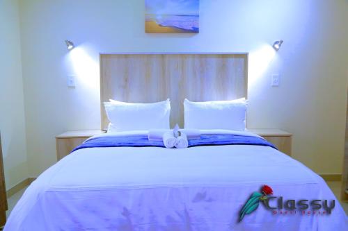 a large white bed with a red flower on it at Classy Guest House in Johannesburg