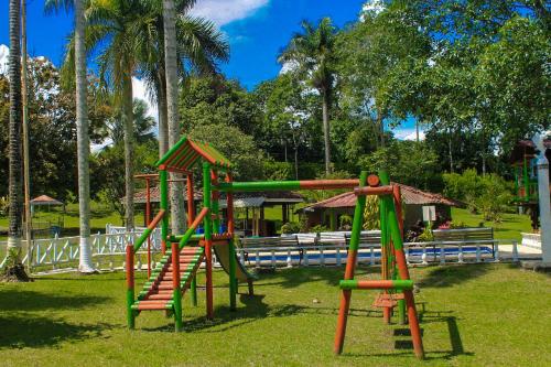 a playground with a slide in a park at Room in Lodge - Family Cabin With River View in Rizaralda