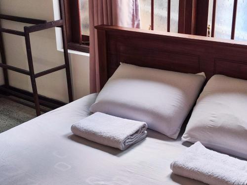 a bed with two pillows sitting on top of it at Schatzi's Hideaway in Tangalle