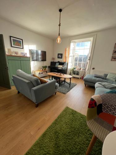 Spacious and cozy apartment in the heart of Haddington في هادينغتون: غرفة معيشة مع أريكة وطاولة