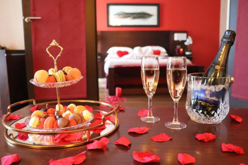 a table with a bottle of champagne and two wine glasses at Hotel de Berny in Antony