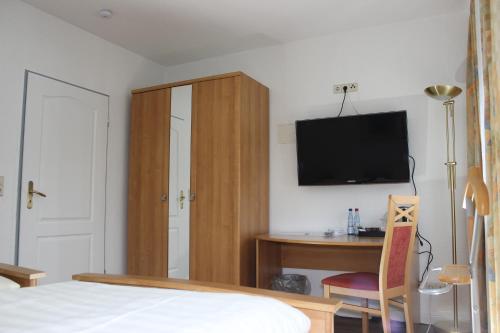 a bedroom with a bed and a desk and a tv at Aalto Hotel in Hannover