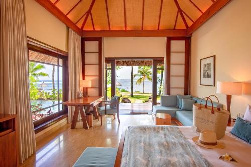 a living room with a couch and a table at Shanti Maurice Resort & Spa in Bel Ombre