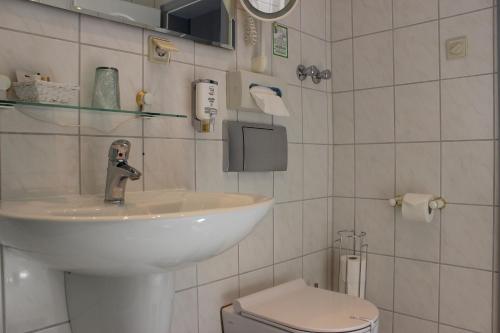 a bathroom with a sink and a toilet at Aalto Hotel in Hannover