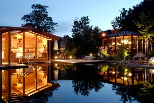 a house with a pool in the yard at night at Wellnessgarten-Hotel in Waging am See