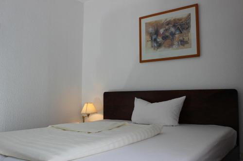 a bedroom with a white bed and a picture on the wall at Aalto Hotel in Hannover