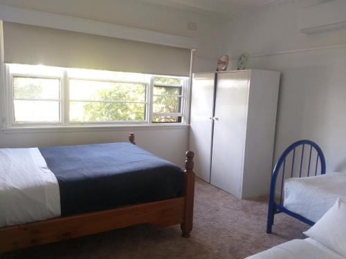 1 dormitorio con 2 camas y nevera blanca en Peaceful Home en Bendigo