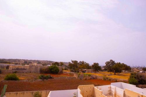 a view of a desert with buildings and trees at Il-Qastna Holiday House in Żejtun