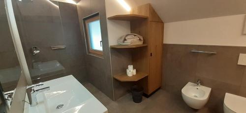 La salle de bains est pourvue d'un lavabo, de toilettes et d'un miroir. dans l'établissement Editlodge "Dessura", à Badia