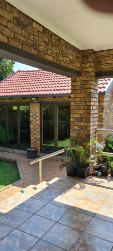a brick house with a bench in front of it at Hornbill Helipad 1 in Centurion