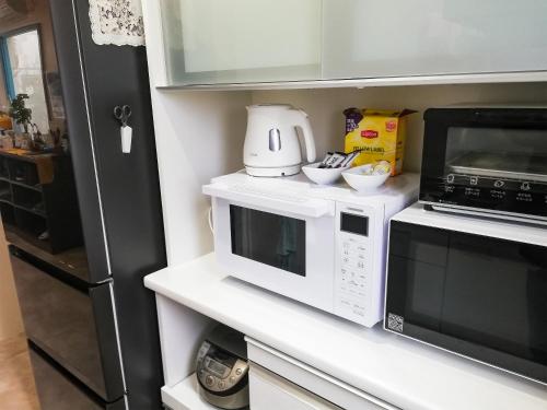 a kitchen with two microwaves on a counter at Room Biotop YOMITAN in Yomitan