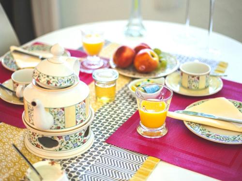 a table with a tea pot and plates of food at Au Bien Venu in Noé