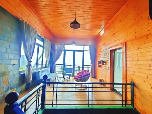 a room with a balcony with wooden walls at Sa Mộc House Tam Đảo - Venuestay in Vĩnh Phúc