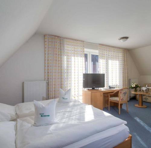 a bedroom with a white bed with two pillows on it at Hotel Restaurant Brintrup in Münster