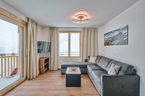 a living room with a couch and a table at 1400 FlexenLodge in Stuben am Arlberg