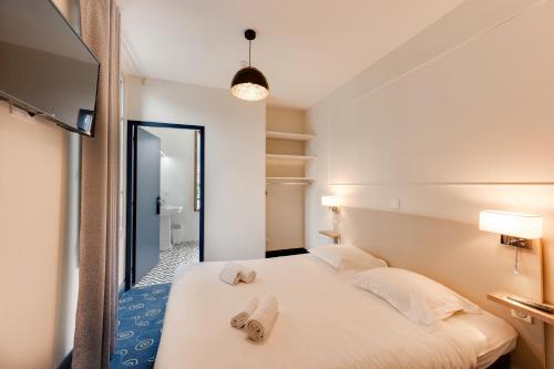 - une chambre avec un lit et des serviettes dans l'établissement Le Pavillon des Fleurs, à Menthon-Saint-Bernard