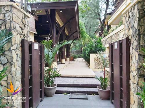 an entrance to a building with potted plants at Paradise Garden Hotel and Convention Center Boracay Powered by ASTON in Boracay