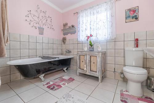 a bathroom with a black bath tub and a toilet at The French Affaire in Parys