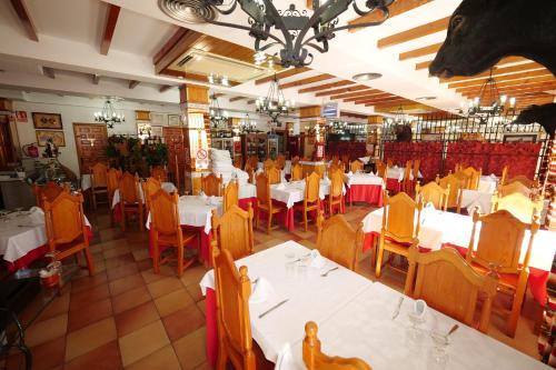 a restaurant with white tables and yellow chairs at Hotel Flor de la Mancha in La Roda